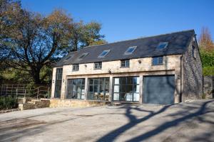 a large stone building with a garage at Lakeview Barn, sleeps 5-7 Guests new inside in Matlock