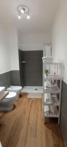 羅馬的住宿－Appartamento Le Vigne di Roma，浴室设有卫生间和带毛巾的白色架子。