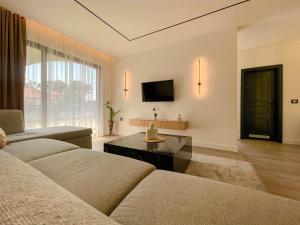 a living room with a couch and a tv at Botanica Boutique Hotel in Ulcinj