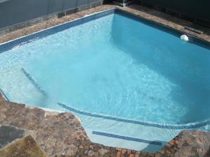 a large swimming pool with blue water at Leeuwenzee Guesthouse in Cape Town