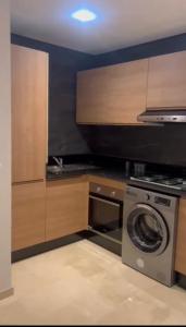 a kitchen with a washing machine and a washer at Résidence taourirt Taghazoute bay in Taghazout