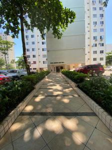 a sidewalk in front of a building with cars parked at Apartamento 2 quartos Rio Centro - Barra Olímpica in Rio de Janeiro