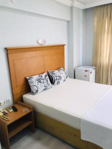 a bedroom with a large bed with a wooden headboard at Begumhan Pansiyon in Antalya