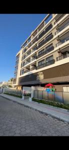 ein großes Wohnhaus mit einem Bürgersteig davor in der Unterkunft Areias de Bombas in Bombinhas