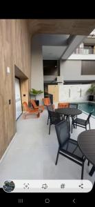 ein Wohnzimmer mit Tischen, Stühlen und einem Pool in der Unterkunft Areias de Bombas in Bombinhas + 13 Fotos