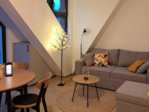 Una sala de estar con un sofá y mesas. en Apartman Yellow Moon, en Divčibare