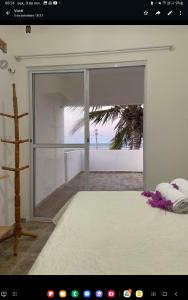 a room with a sliding glass door with a view of a beach at VILLA Enzo in Acaraú