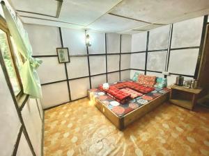 ein Zimmer mit einem Bett in der Ecke eines Zimmers in der Unterkunft Chumang River Nest in Thode