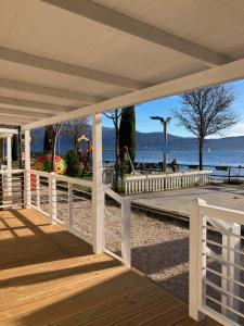 une terrasse en bois avec vue sur la plage dans l'établissement Villaggio Turistico Maderno, à Toscolano Maderno