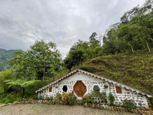ein kleines Haus mit Blumen an der Seite eines Hügels in der Unterkunft Chumang River Nest in Thode