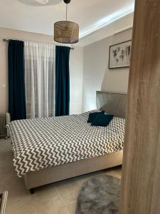 1 dormitorio con 1 cama grande y cortinas azules en Lux Apartman Jovana en Žabljak