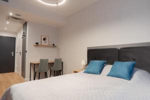 - une chambre avec un grand lit et des oreillers bleus dans l'établissement Apartament Poznań, à Poznań