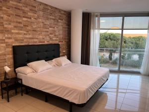 um quarto com uma cama grande e uma parede de tijolos em FIRA Gran Vía 2 - Private Rooms in a Shared Apartment - Habitaciones Privadas en Apartamento Compartido em L'Hospitalet de Llobregat