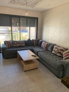 uma sala de estar com um sofá e uma mesa de centro em Nice appa em Kenitra