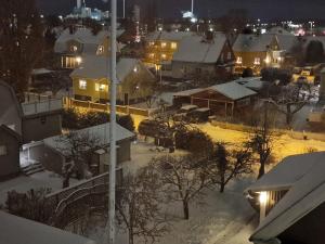 a snow covered city at night with houses at Noah Longstay Apartment in Västerås