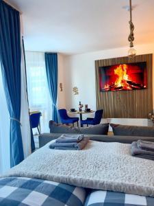 - une chambre avec un lit orné d'une peinture au feu sur le mur dans l'établissement Blue Apartment Pirin Golf & Spa, à Bansko