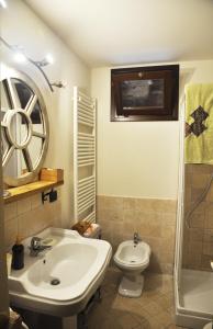 a bathroom with a sink and a toilet and a shower at Di-vinodormire in La Morra