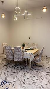 tavolo da pranzo con sedie e lampadario pendente di شقة مميزه a Muhayil