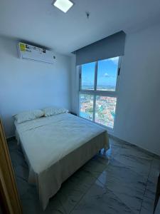 sypialnia z dużym łóżkiem i dużym oknem w obiekcie Unlimited Ocean View - The Sands w Panamie