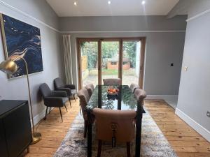 ein Wohnzimmer mit einem Tisch und Stühlen in der Unterkunft Large, Spacious Home in London with Modern Interior in Finchley