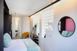 a bedroom with a bed and a mirror on the wall at Penthouse Studio stunning Table Mountain view in Cape Town