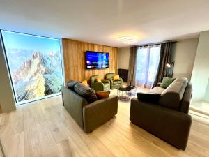 a living room with two couches and a large window at Appartements Chalet Lauranoure Centre Station in Les Deux Alpes