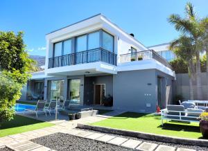 a white house with chairs and a patio at Villa Boutique La Quinta in Santa Úrsula