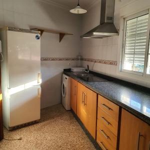 a kitchen with a white refrigerator and a sink at Apartamento en San José - Rinconada II in San José de la Rinconada