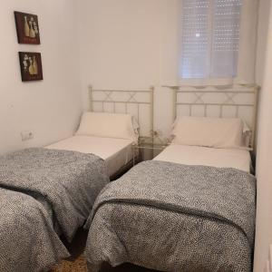 two twin beds in a bedroom with a window at Apartamento en San José - Rinconada II in San José de la Rinconada