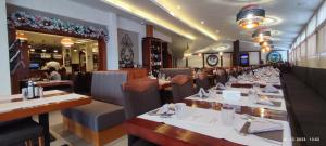 ein Speisesaal mit Tischen und Stühlen in einem Restaurant in der Unterkunft Apartman Standard Lux u Kraljevim Čardacima in Kopaonik + 33 Fotos