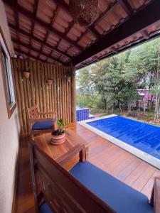 a patio with a table and a swimming pool at Villa Tereza in Alto Paraíso de Goiás