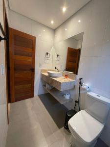 uma casa de banho com um lavatório, um WC e um espelho. em Villa Tereza em Alto Paraíso de Goiás