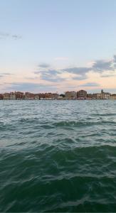 ein großer Wasserkörper mit Gebäuden im Hintergrund in der Unterkunft CA, BOTTE in Venedig