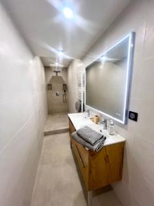 uma casa de banho com um lavatório e um espelho grande em Appartements Chalet Lauranoure Centre Station em Les Deux Alpes