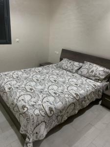 uma cama com um edredão branco num quarto em Nice appa em Kenitra