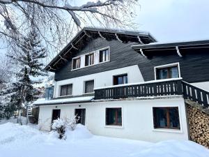 Una gran casa blanca con nieve en el suelo en Appartements Chalet Lauranoure Centre Station en Les Deux Alpes