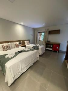 um quarto de hotel com duas camas e uma janela em Villa Tereza em Alto Paraíso de Goiás