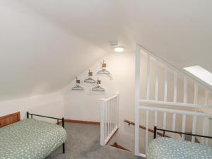 a room with a staircase with a bed and shelves at Bay Tree Cottage in Pickering