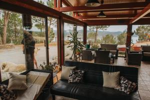 a living room with a black leather couch and a window at Poioruivo in Santa Clara-a-Velha