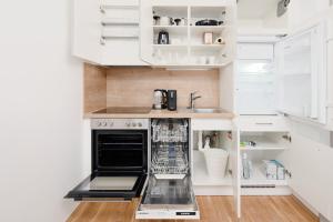 a small kitchen with a sink and a dishwasher at Oidahome - Apartment am Hauptbahnhof - contactless Self-Check-IN in Graz