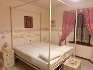 a bedroom with a four poster bed with a canopy at Villa Valentina in Sestola