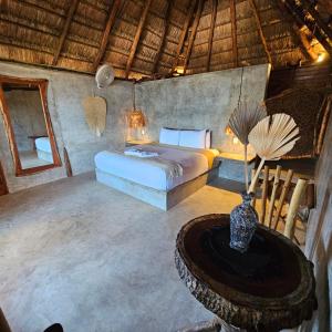 um quarto com uma cama e uma mesa num quarto em Cabañas Playa Condesa em Tulum
