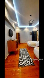 a bedroom with two beds and a tv and a rug at توت كينج بيراميدز فيو in Cairo