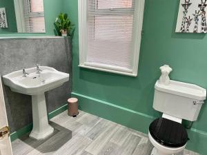 La salle de bains est pourvue de toilettes et d'un lavabo. dans l'établissement Spacious, Cosy 3 Bedroom House in Preston., à Preston