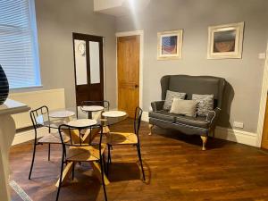 un soggiorno con divano, tavolo e sedie di Spacious, Cosy 3 Bedroom House in Preston. a Preston