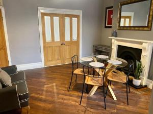 une salle à manger avec une table, des chaises et une cheminée dans l'établissement Spacious, Cosy 3 Bedroom House in Preston., à Preston