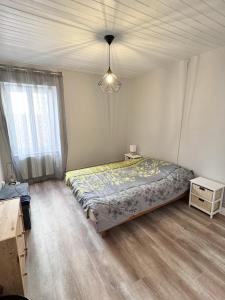 Un dormitorio con una cama y una lámpara. en Charmante maison de Bourg, dans les hauteurs Auvergnate ! en Nonette