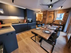 a kitchen and dining room with a wooden table and chairs at Appartement cosy pour 6 aux Gets avec WIFI et terrasse - FR-1-598-154 in Les Gets +8 photos
