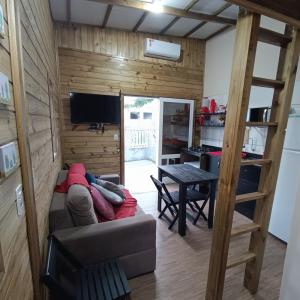 ein Wohnzimmer mit einem Sofa und einem Tisch in der Unterkunft Dunas Tiny House Casa 2 in Florianópolis
