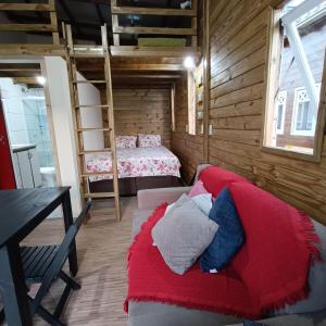 ein Schlafzimmer mit einem Sofa und einem Bett in einem Zimmer in der Unterkunft Dunas Tiny House Casa 2 in Florianópolis